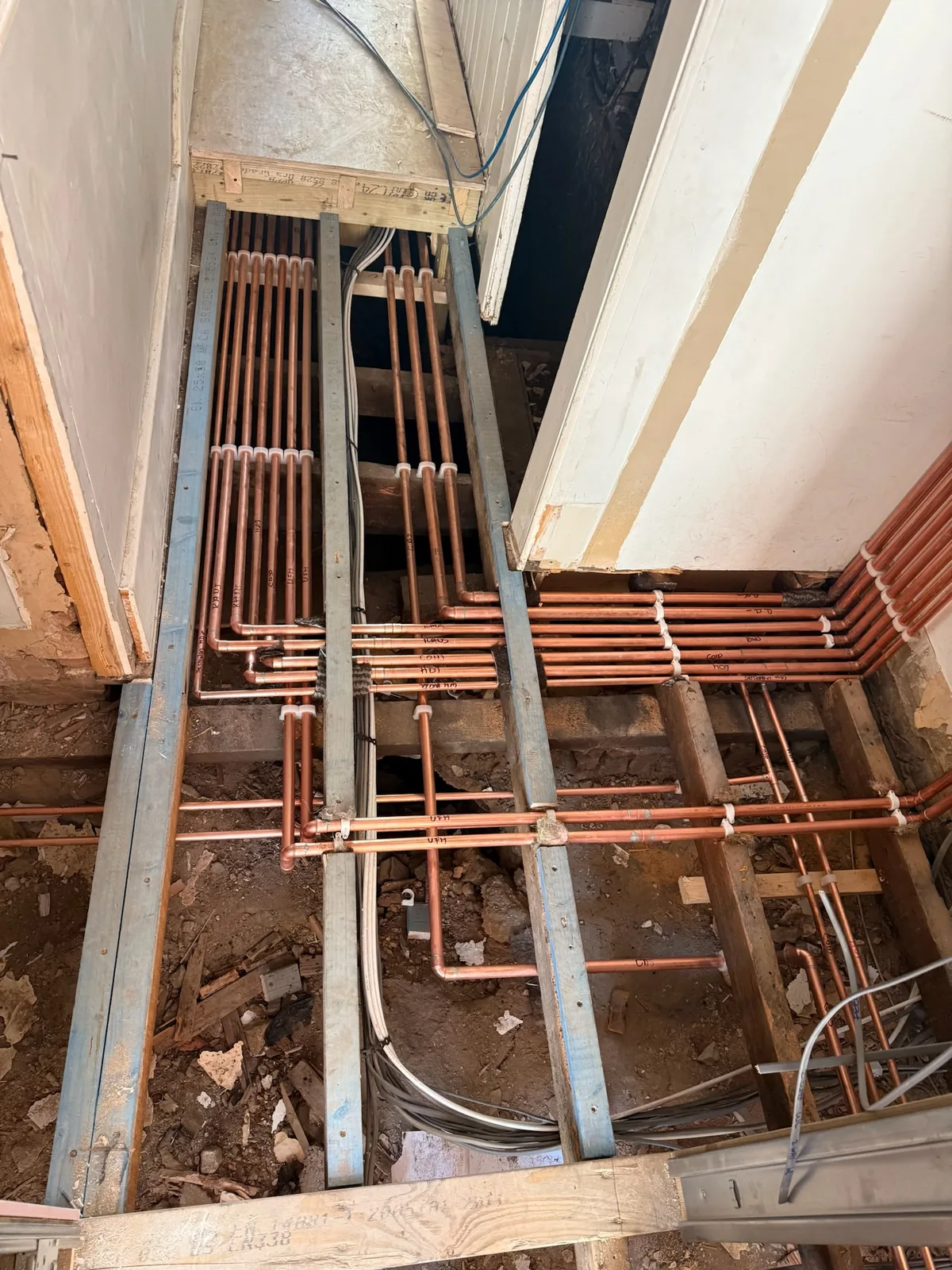 Copper pipework run between floor joists ready for second fix